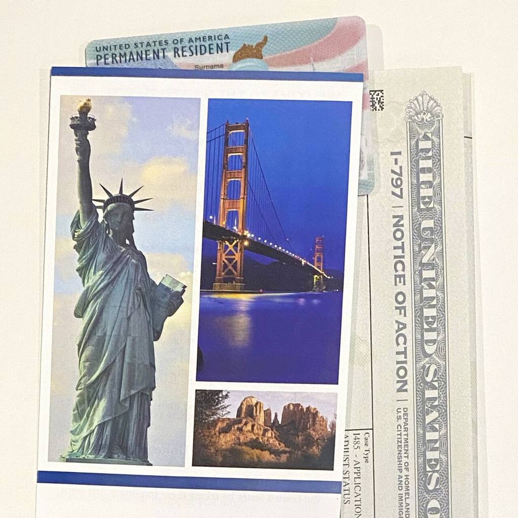 A green card, a USCIS welcome guide for new immigrants, and an I-797 approval notice for a green card application
